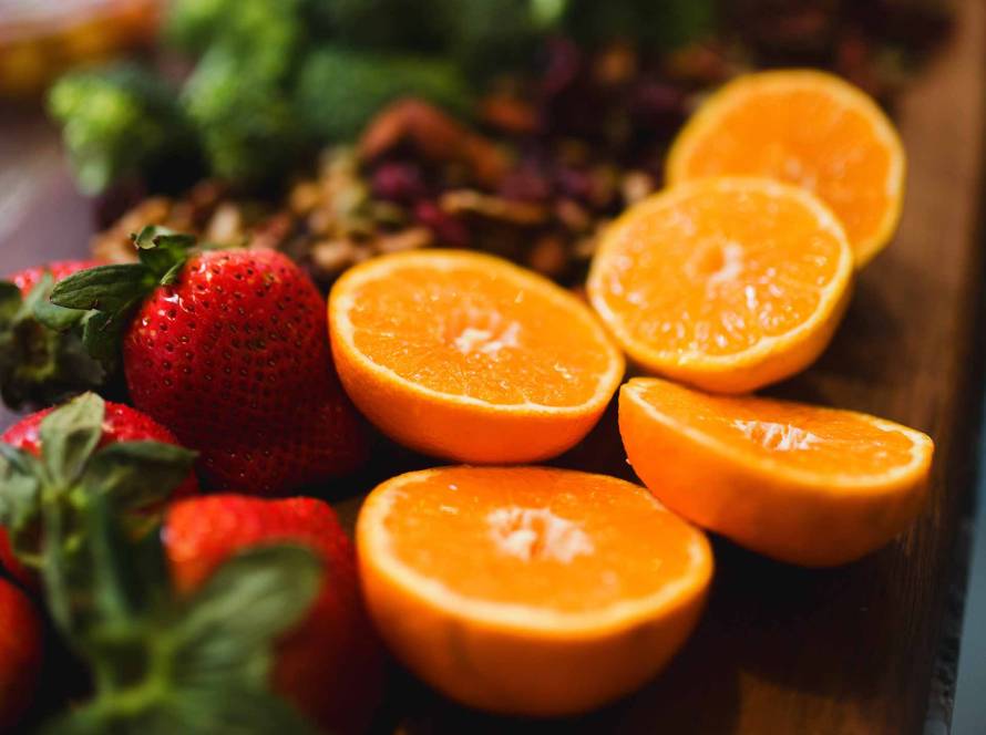 Fresas, naranjas y verduras sobre una mesa